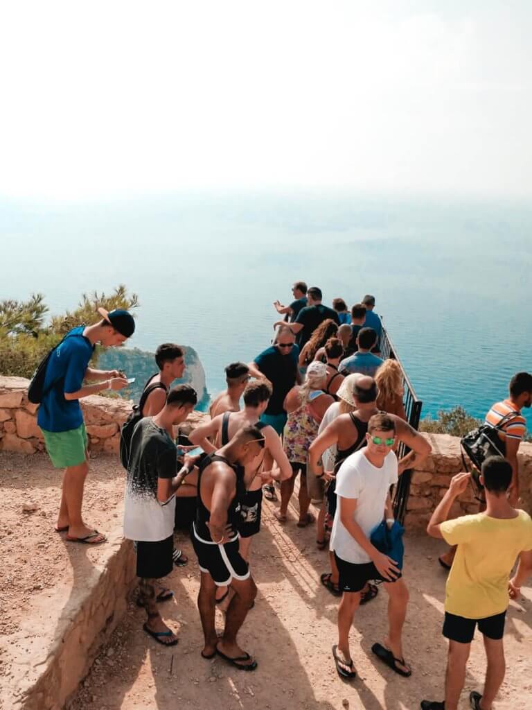 Visitors lining up at the lookout point, a secret place in Zakynthos, eager to view the stunning Navagio Beach