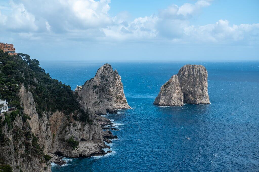 Iconic Faraglioni rocks off Capri's coast, a natural wonder accessible from Napoli for an unforgettable day trip.