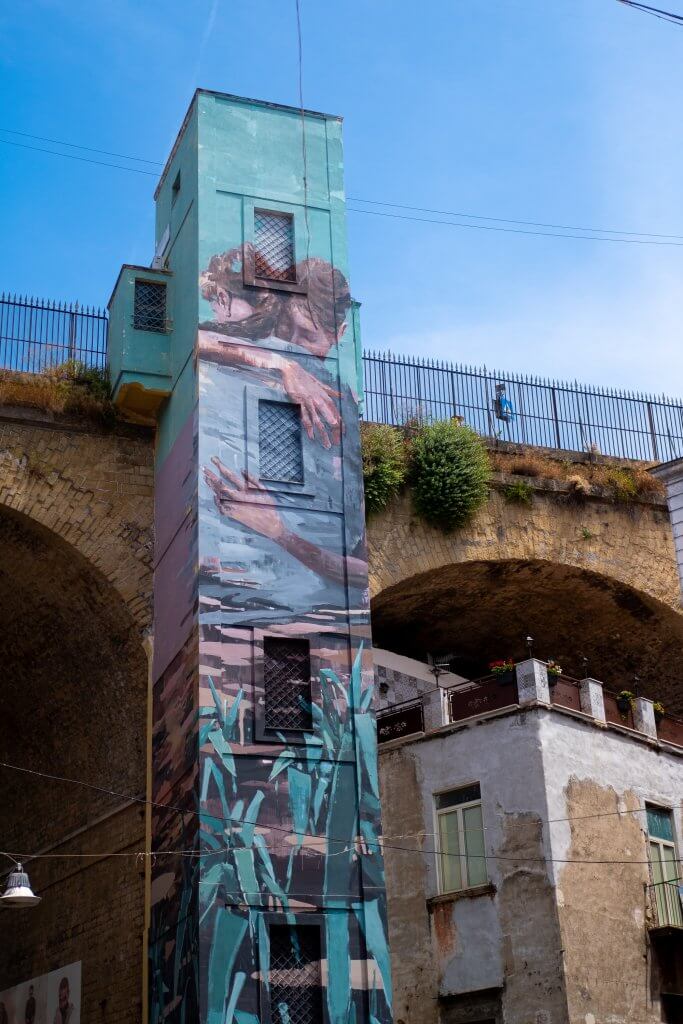 Vibrant street art in Naples depicting a couple hunting, blending modernity with tradition.
