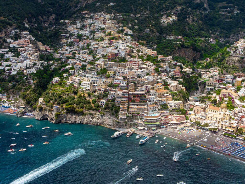 Focused view of Positano's landscape with a blurred figure in the foreground, highlighting the serene beauty of the Amalfi Coast near Napoli for travelers seeking tranquility
