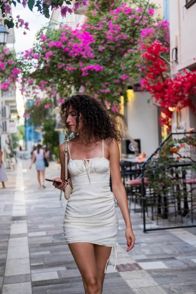 Kate strolling through Nafplio's bougainvillea-lined streets in a white dress